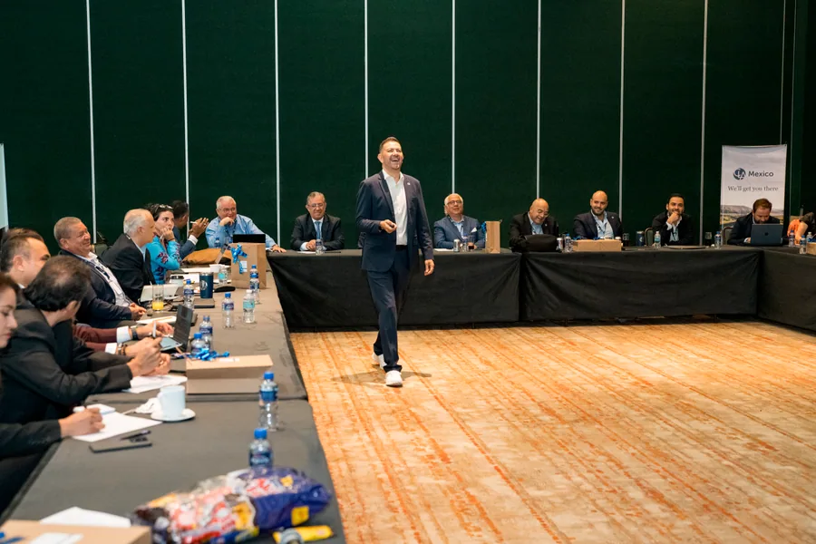 Cuauhtli Arau dialogando con un grupo de directivos reunidos en una asamblea.
